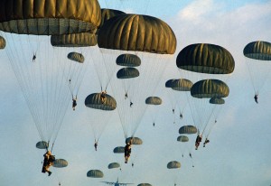 Members of the 82nd Airborne Division parachute from a C-130 Hercules aircraft during the joint Exercise BRIGHT STAR '83.